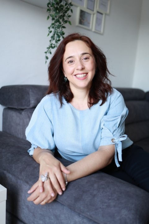 Cátia Ferreira, Educadora Parental e Coach de Adolescentes, sentada num sofá a sorrir